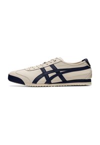 Beige sneaker with dark blue accents, featuring leather upper, textured front, and rubber sole with a patterned tread. Lace-up closure.