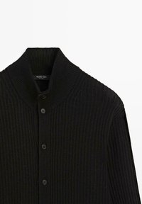Černý žebrovaný cardigan s vysokým límcem a předním zapínáním na knoflíky. Vyznačuje se měkkou texturou a výrazným pleteným vzorem, označený značkou Massimo Dutti.