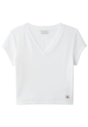 Top scurt alb, cu mâneci scurte, din material reiat, cu decolteu în V, cu etichetă Calvin Klein Jeans la gulerul din spate și cu mică emblemă CK pe tiv.