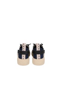 Sandales noires et bleu marine avec une semelle beige texturée, dotées d'une sangle arrière et d'une garniture en dentelle décorative le long du talon. Nom de la marque embossé sur la semelle.