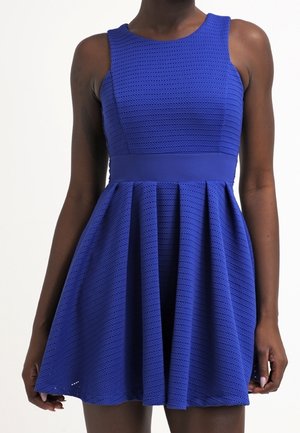 Blauwe fit-and-flare jurk, textuurestof met geperforeerd patroon, mouwloze uitvoering, taillebandaccent, rok loopt wijd uit vanaf de taille.