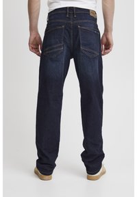 Temno modri jans jeans s ravnim krojem, vidnim šivom in dvema zadnjima žepoma. Strukturirana tkanina z rahlim leskom.
