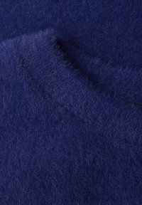 Blødt, dybtblåt strikket stof med en fuzzy tekstur, der har en blød drapering og subtile nuancer i farven på hele overfladen.