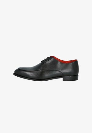 Zapato de vestir de cuero negro con acabado liso y punta redonda. Cuenta con cinco ojales, interior rojo y un tacón bajo y plano.