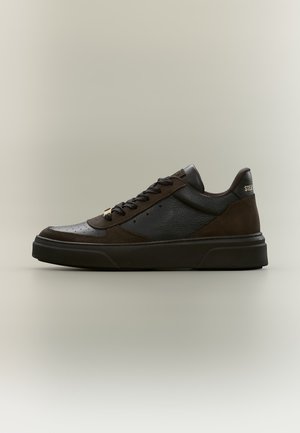 Baskets basses en cuir et daim marron foncé avec semelle et lacets noirs, perforations latérales et texte de marque doré sur la languette du talon.