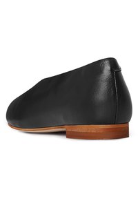 Scarpa flat nera in pelle con punta arrotondata e tacco basso in legno; texture liscia con dettagli di cucitura minimi. La suola sembra resistente.