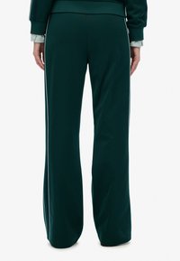 Teal sweatpants med en afslappet pasform, der har hvide sideliv, en blød tekstur og design med lige ben. Elastisk talje bagpå.