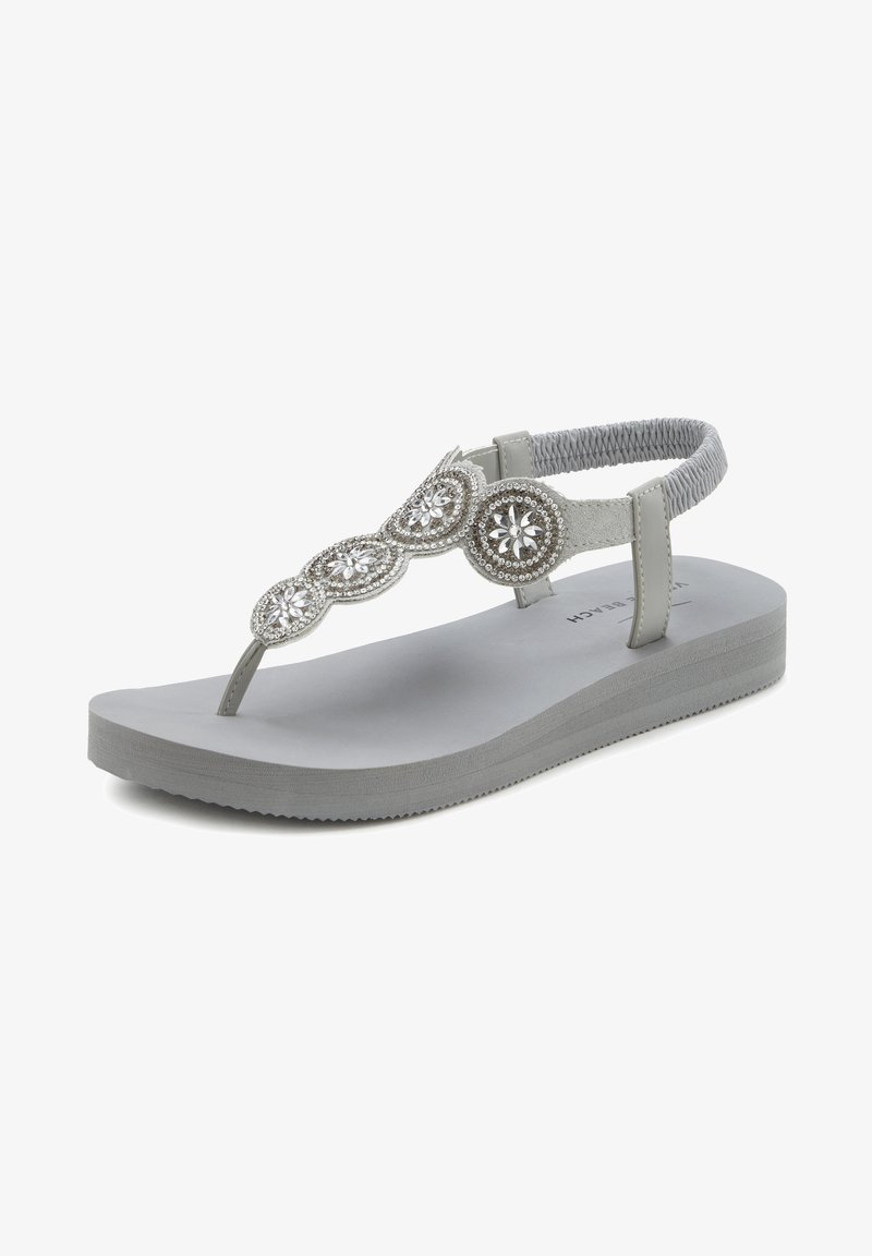 Gray thong sandal with a textured ankle strap, embellished with silver circular accents and a cushioned footbed for comfort.