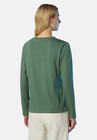 Grünes Langarmhemd mit rundem Ausschnitt und geradem Schnitt, aus weichem Stoff und minimalen Nahtdetails am Rücken.