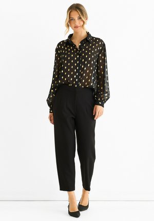 Black sheer blouse with gold leaf pattern, button-up design, long sleeves, paired with black trousers, slim-fit, tapered leg.