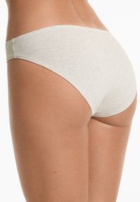 Light gray cotton underwear with a seamless design, featuring a low-rise fit and smooth texture. Limited visible stitching and minimal coverage.