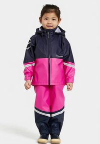 Sadeasu ja housut, värit tummansininen ja kirkas pinkki, vetoketjulla, hupulla ja heijastinraidoilla. Vedenpitävä materiaali ja joustavat hihansuut.