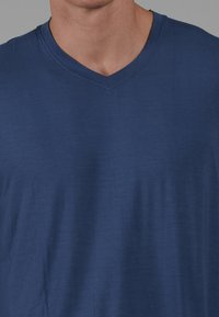 Navy blauwe V-hals t-shirt, gemaakt van zacht materiaal. Beschikt over korte mouwen en een relaxte pasvorm, met een gladde textuur.