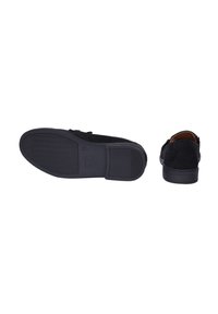 Decolte in suede nero con suola in gomma piatta, caratterizzati da un design semplice e una suola testurizzata. Presentano cuciture dettagliate e accenti minimali.