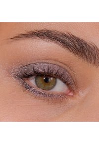 Närbild på ett öga med hasselbrun iris, tydliga fransar och glittrigt grå ögonskugga, som framhäver ögonbrynets form och släta hudstruktur.