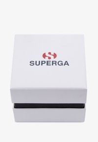 Valge paberkarp sujuva tekstuuriga, musta alusega. Ülaosas on silmapaistvalt keskendatud punane ja must "SUPERGA" logo.