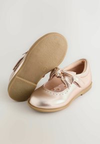 Metalen roze Mary Jane-schoenen met een ronde neus, strikdetail op het bandje en een gestructureerde zool. Het interieur heeft een bloemenpatroon.