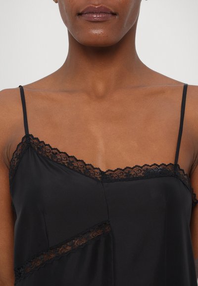 Svart satin camisole med delikat spetskant längs halsringningen och axelbanden, med en avslappnad passform och lätt glans.