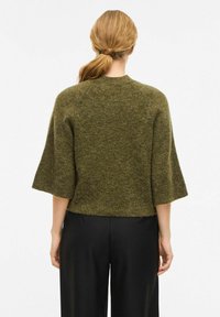 Maglione a maglia verde oliva con maniche a tre quarti e scollo rotondo. Tessuto morbido, vestibilità corta in vita, senza chiusure visibili.