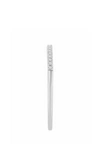 Strieborný prsteň s hladkým pásikom, na jednej strane zdobený radom malých, priehľadných drahokamov, predstavujúci minimalistický dizajn.