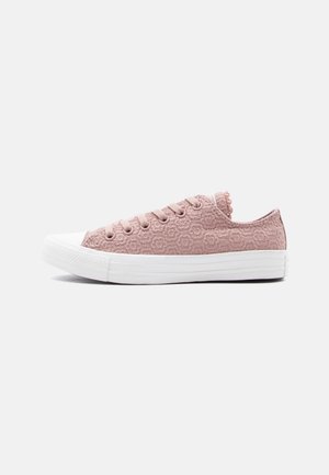 Zapatilla baja en rosa empolvado con tejido texturizado floral, cordones en el frente y suela y puntera de goma blanca.