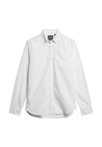 Camisa blanca de manga larga con botones, hecha de algodón, que presenta un bolsillo en el lado izquierdo del pecho, cuello abotonado y dobladillo curvado.