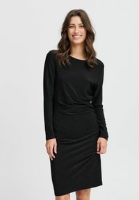 Schwarzes, langärmeliges Kleid aus strukturiertem Stoff mit einem subtilen Schimmer. Verfügt über eine geraffte Taille und eine figurbetonte Silhouette.