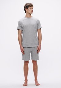 Helehall puuvillane t-särk ja lühikeste pükstega komplekt, ümara kaelusega, lühikeste varrukatega, minimalistliku disainiga, rinnal peene brändinguga.