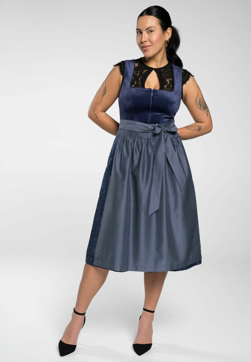 Navyblauwe jurk met een kantaccent op het lijfje, een nauwsluitende taille en een vloeiende rok. Satijnafwerking, strikdetail in de taille en een zijbloemmotief.