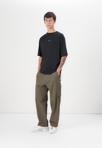 Oakley STACKED TEE - T-Shirt print - blackout