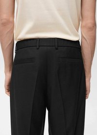 Pantalones negros con cinturilla plana, presillas para cinturón y dos bolsillos traseros. La tela es suave y ajustada, mostrando un diseño de pierna recta.