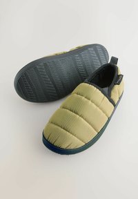 Zelené nadýchané papuče s prešívaným dizajnom a čiernymi gumovými podrážkami. Majú slučku pre jednoduché obúvanie. Podrážka má vzor rybej kosti.