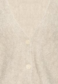 Light beige, textured cardigan with two visible round buttons and a V-neck collar.