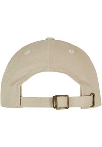 Pălărie de baseball bej cu vârful curbat, din material de bumbac, și curea ajustabilă cu cataramă metalică în spate. Prezentă ocus de cusătură albă.