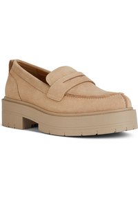 Beige mockasiner i sammet med rund tå, med en upphöjd söm och en kraftig gummisula med texturerade spår.