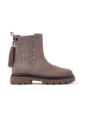 Stivale alla caviglia in suede marrone con suola spessa, nappina decorativa e accenti con motivo a stella sul lato, caratterizzato da un design flessibile.
