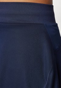 Navy athletic shorts featuring a smooth, breathable fabric with a wide waistband and seamless side panels for comfort and flexibility.