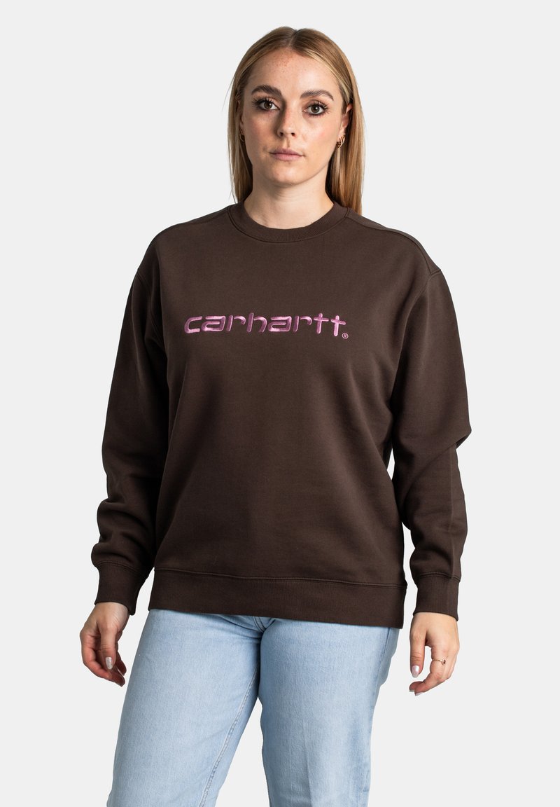 Felpa marrone con scollo rotondo e maniche lunghe. Presenta un logo "carhartt." in rosa stampato sul davanti. Tessuto morbido al tatto.