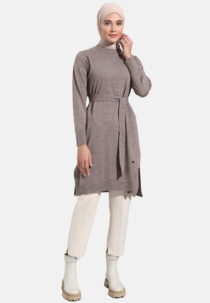 Knit long-sleeve dress in taupe with a belt, featuring side slits. Paired with cream trousers and white ankle boots. Smooth texture.