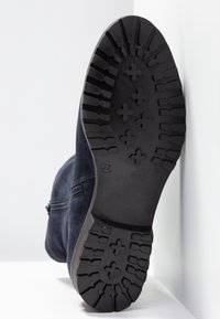 Námořnické semišové kotníkové boty s robustní černou gumovou podrážkou, mají texturovaný vzor na podrážce a boční zip pro snadné obouvání. Velikost 37.