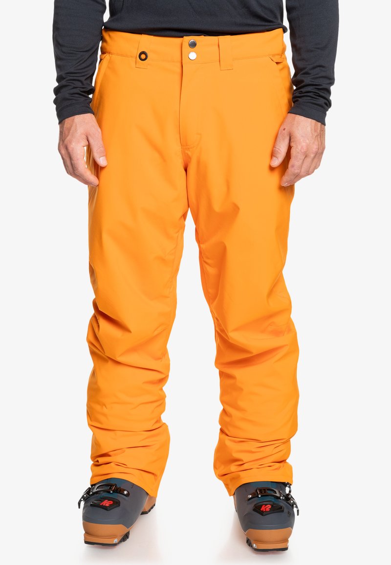 Pantalones de esquí naranja brillante con un exterior liso y resistente al agua, con cierre de botón, corte recto y bolsillos en los lados.