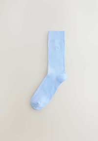 Calcetín de algodón azul claro con puño acanalado y textura suave, con un pequeño logo bordado cerca de la parte superior.