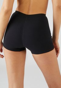 Calzoncillos de algodón negros con una textura suave y una cinturilla elástica. Presentan un diseño sencillo, que ofrece una cobertura completa con una forma ajustada.