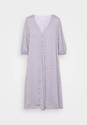 Vestido lavanda com decote em V, mangas três quartos e um corte solto. Apresenta um padrão de bolinhas pretas em todo o tecido.