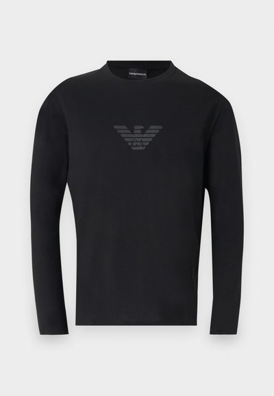 Μαύρο μακρυμάνικο μπλουζάκι με στρογγυλή λαιμόκοψη και διακριτικό σκοτεινό γκρι λογότυπο αετού Emporio Armani στο κέντρο του στήθους.