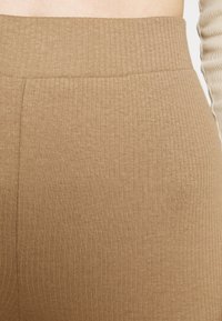 Tan ribbade leggings med hög midja, som har en mjuk textur och stretchigt tyg för komfort.