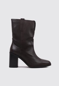 Brown leather ankle boot with a square toe, chunky block heel, and side zipper. Smooth texture and simple design without embellishments.