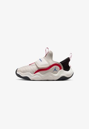 Biało-czerwone sportowe buty typu slip-on z falistą podeszwą, niebieskim logo Jumpman oraz pętelkami do ściągania na języku i pięcie.