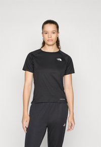 Μαύρο αθλητικό μπλουζάκι κοντομάνικο με στρογγυλή λαιμόκοψη και ριγωτή υφή, διαθέτοντας άσπρο λογότυπο στο αριστερό στήθος και ελαφρύ ύφασμα.