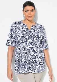 Námořnická a bílá květinová blůza s krátkým rukávem, výstřihem do V a volným střihem. Obsahuje kombinaci vzorů listů a hladkého bavlněného vzhledu.